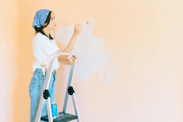 Interior painting in Boise: painter on a stepladder rolling a wall